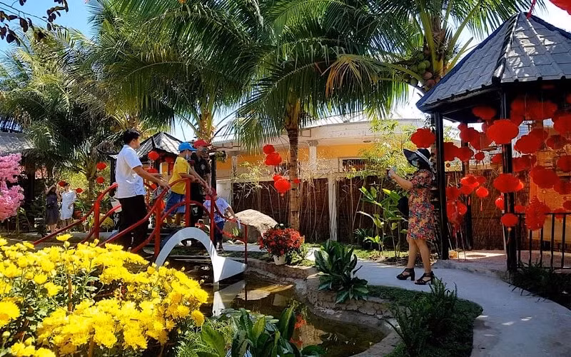 Du khách thích thú chụp ảnh lưu niệm tại làng du lịch Ông Đề.