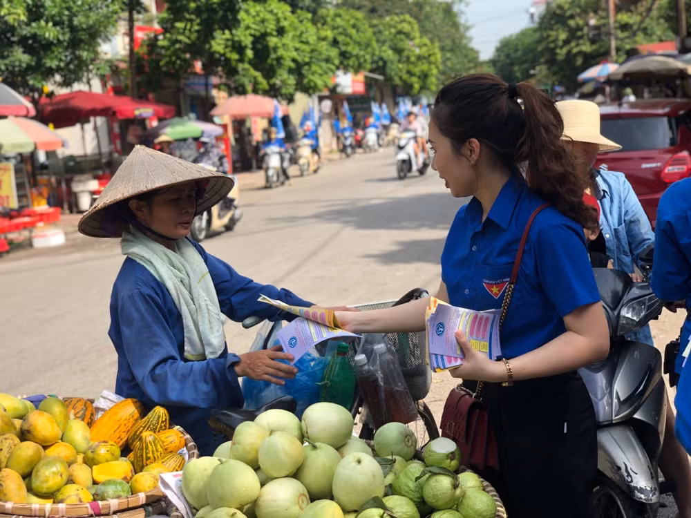 Người dân lao động tự do được cán bộ BHXH tư vấn, hướng dẫn về BHXH tự nguyện. Ảnh: Trung Tâm