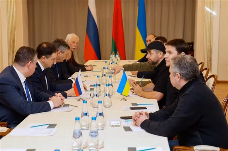 Các thành viên phái đoàn Nga (trái) và Ukraine tại vòng đàm phán ở vùng Gomel, Belarus, ngày 28/2/2022. (Ảnh: AFP/TTXVN)