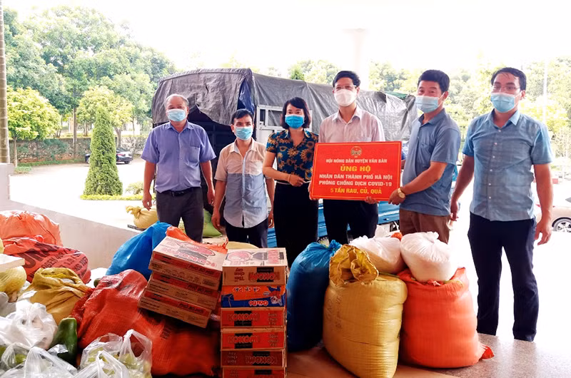 Chủ tịch Hội Nông dân tỉnh Lào Cai (người cầm biển, đứng giữa) tại buổi quyên góp, ủng hộ lương thực, rau xanh giúp người dân TP Hà Nội.