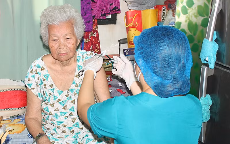 Tiêm vaccine tại nhà cho người già yếu, di chuyển khó khăn ở quận 10, Thành phố Hồ Chí Minh trong dịp Tết Nguyên đán 2022.