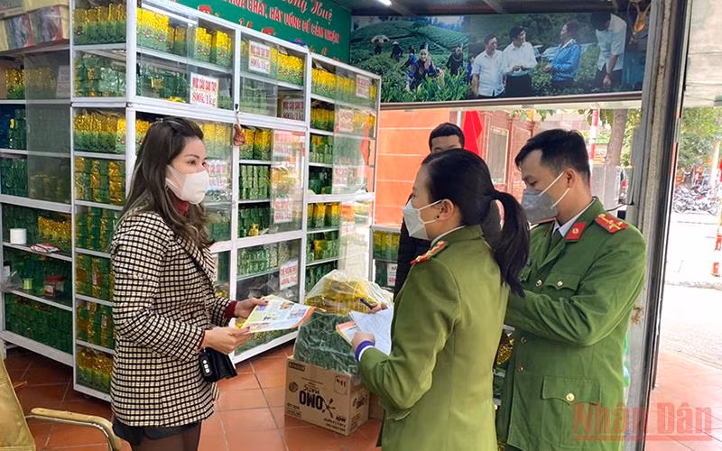 Cán bộ Đội cảnh sát phòng cháy, chữa cháy và cứu nạn cứu hộ (Công an quận Thanh Xuân, Thành phố Hà Nội) phát tờ rơi, tuyên truyền phòng chống cháy nổ tại một cửa hàng kinh doanh trà tại phường Thanh Xuân Bắc.