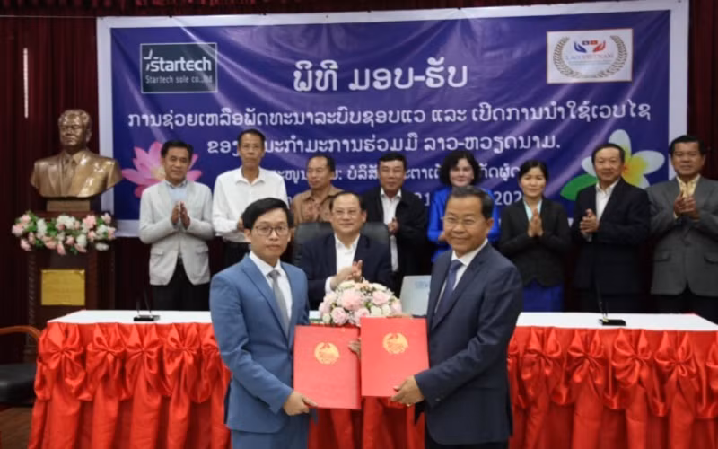Thứ trưởng Kế hoạch và Đầu tư, Phó Chủ tịch Thường trực Ủy ban Hợp tác Lào - Việt Nam Khamphoi Keokinnaly (phải) tại lễ trao biên bản tài trợ dự án.