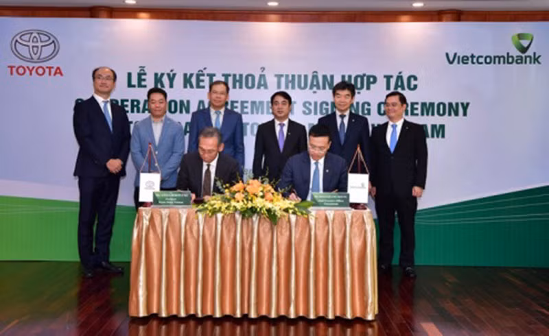 Ông Hiroyuki Ueda - Tổng Giám đốc Toyota VN (ngồi bên trái) và ông Phạm Quang Dũng - Tổng Giám đốc Vietcombank (ngồi bên phải) ký kết thỏa thuận hợp tác giữa Vietcombank và Toyota VN.