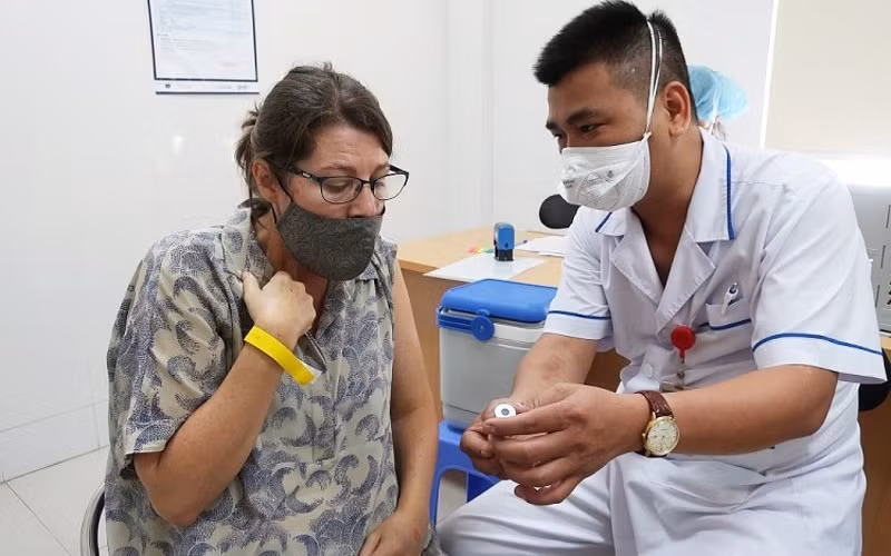 Nhân viên y tế cung cấp thông tin vaccine cho một cán bộ của tổ chức Phi chính phủ nước ngoài tại buổi tiêm ngày 13/7 (Ảnh: BV Phổi T.Ư). 