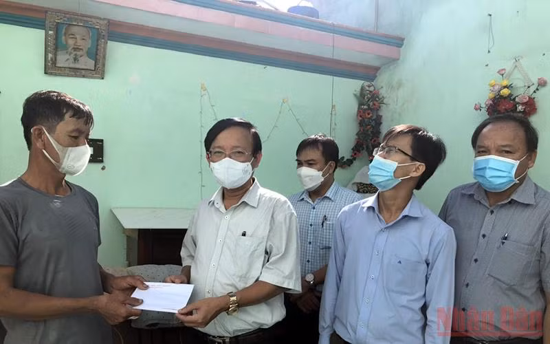 Bí thư Huyện ủy Bình Sơn (Quảng Ngãi) Lương Kim Sơn trao tiền hỗ trợ cho gia đình có nhà bị hư hỏng do lốc xoáy.