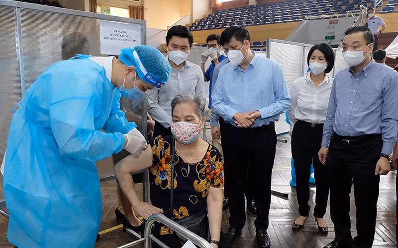 Bộ trưởng Nguyễn Thanh Long kiểm tra điểm tiêm ở nhà thi đấu Trịnh Hoài Đức, thăm hỏi những người tới tiêm. (Ảnh: Bộ Y tế)