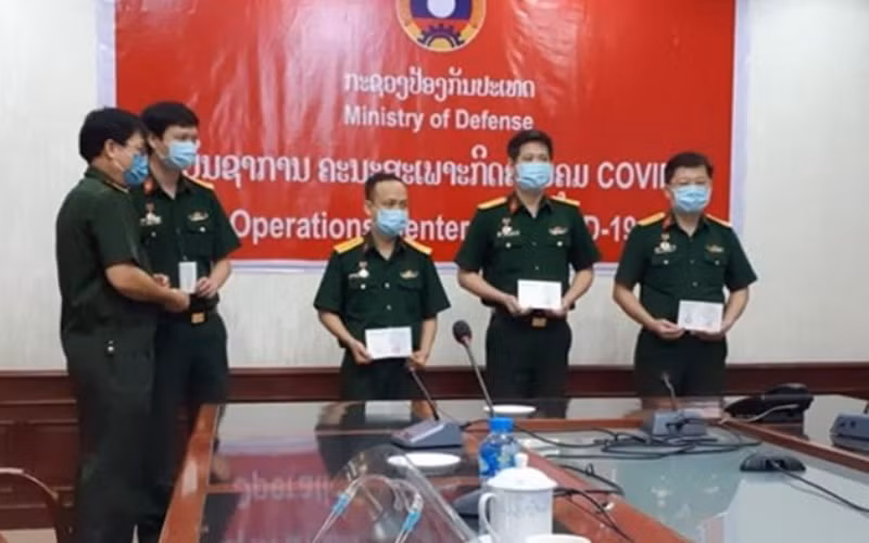Đại tá Lê Văn Đông (bìa phải) và Đoàn chuyên gia Quân y Việt Nam nhận Huy chương Hữu nghị tại Bộ Quốc phòng Lào, ngày 19-5.