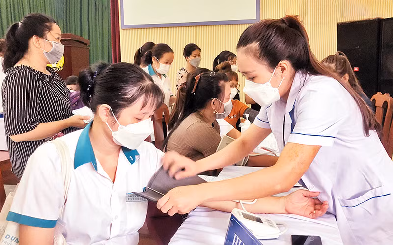 Nữ công nhân được thăm khám sức khỏe hậu Covid-19 tại quận Bình Tân.