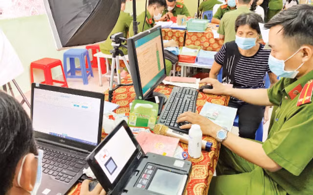 Cán bộ công an hỗ trợ người dân làm thẻ căn cước công dân có gắn chíp tại Nhà văn hóa liên phường Bình Trị Đông, quận Bình Tân. (Ảnh: QUÝ HIỀN)
