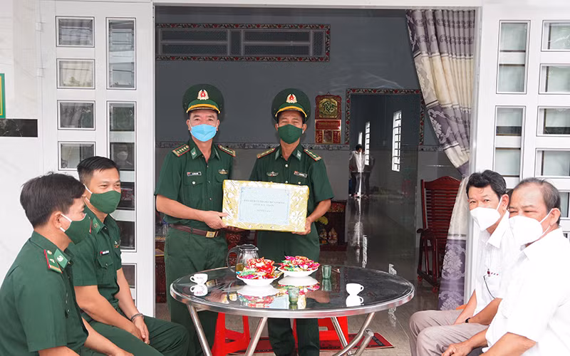 Đại tá Lê Văn Anh, Phó Chính ủy Bộ đội Biên phòng tỉnh Sóc Trăng trao quyết định bàn gia nhà đồng đội cho đồng chí Trung tá Lâm Chí Dũng.