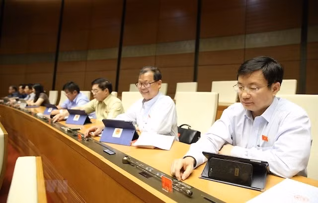 Đại biểu Quốc hội biểu quyết Luật Doanh nghiệp (sửa đổi) sáng 17-6. (Ảnh: DƯƠNG GIANG - TTXVN).