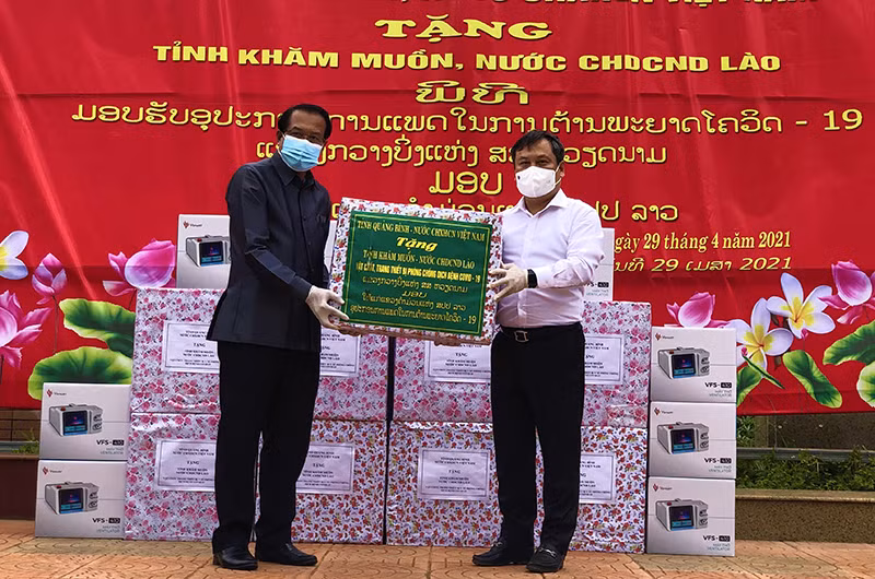 Bí thư Tỉnh ủy Quảng Bình Vũ Đại Thắng (áo trắng) trao tặng thiết bị phòng chống dịch cho lãnh đạo tỉnh Khăm Muộn.