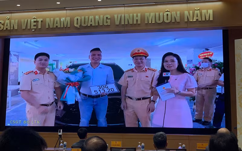 Phòng CSGT Hà Nội trao biển số ô-tô cho anh Nguyễn Việt Hưng - công dân đầu tiên thực hiện thành công dịch vụ công thứ 1.000 trên Cổng Dịch vụ công quốc gia. Ảnh: Quang Hiếu