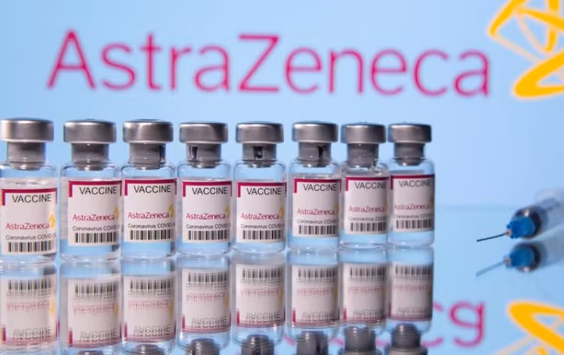 Các lọ vaccine ngừa Covid-19 của Astra Zeneca trước logo của nahf sản xuất được chụp vào ngày 14-3. Ảnh: Reuters.