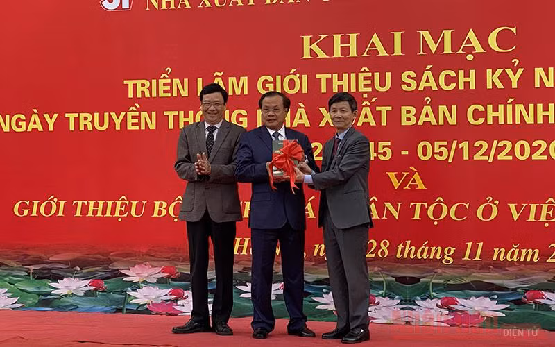Đồng chí Phạm Quang Nghị, nguyên Ủy viên Bộ Chính trị, nguyên Bí thư Thành ủy Hà Nội nhận bộ sách từ lãnh đạo NXB và đại diện nhóm tác giả. Ảnh: TRỊNH DŨNG