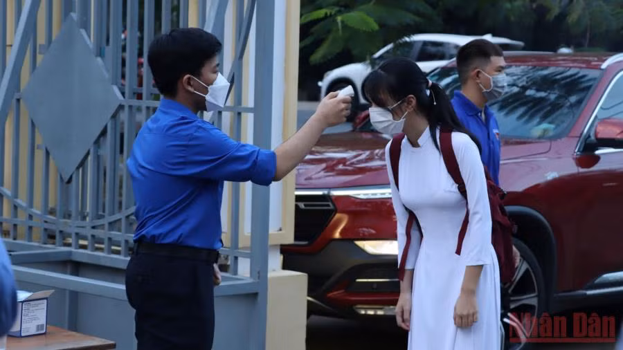 Đo thân nhiệt cho học sinh trước khi vào lớp học trực tiếp tại Đồng Nai. 