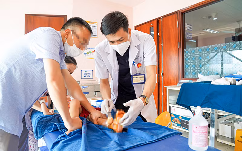 Bác sĩ xử trí vết thương cho bé bị tai nạn cửa trượt tự động. 
