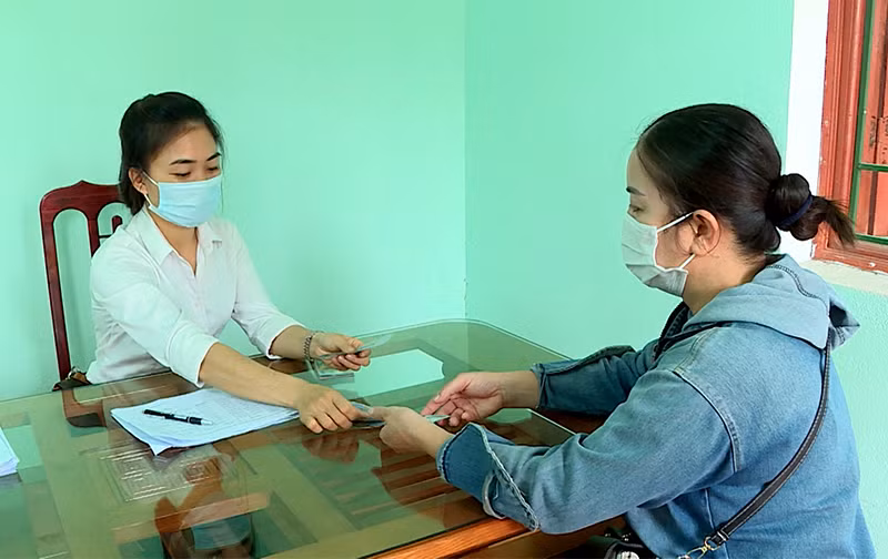 Cán bộ UBND xã Mỹ Bằng, huyện Yên Sơn chi trả tiền hỗ trợ cho đối tượng bị ảnh hưởng do dịch Covid-19.