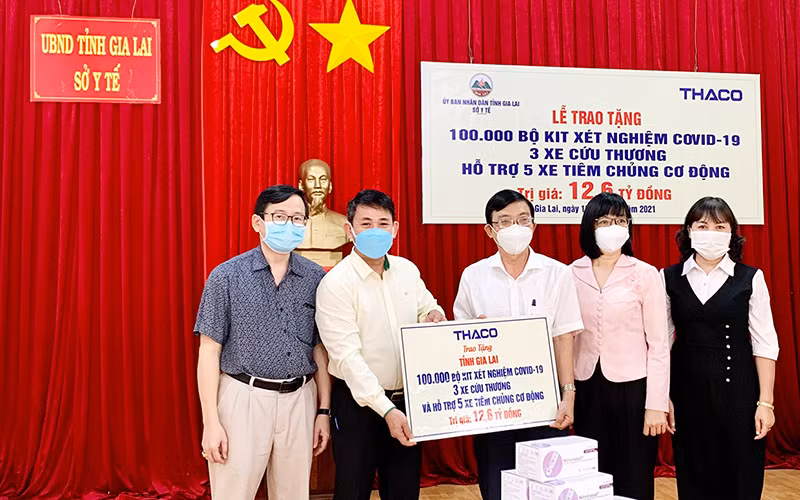 Đại diện THACO trao bảng tượng trưng hỗ trợ cho tỉnh Gia Lai. (Ảnh: Như Nguyện)