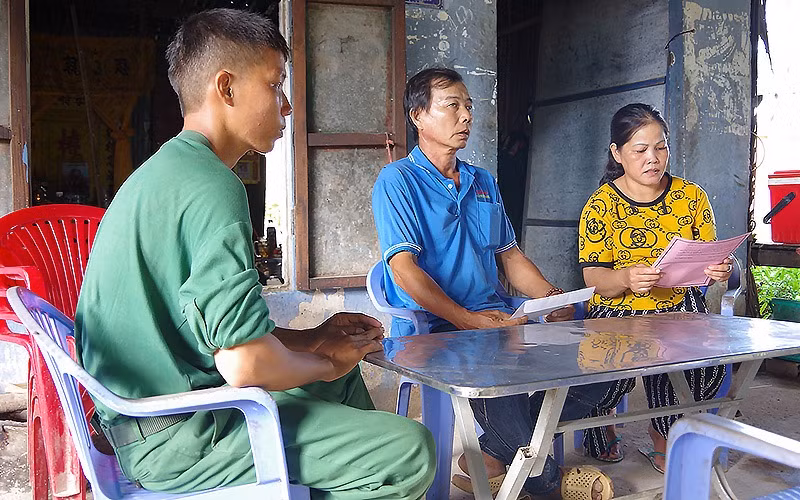 Bà Danh Thị Bé Tư (áo vàng), mẹ quân nhân Huỳnh Thanh Hiếu (Trung đoàn 20, Sư đoàn 330, Quân khu 9) đọc thư của đơn vị gửi trong thời gian con mình được nghỉ phép.