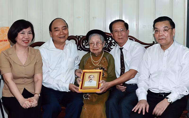 Chủ tịch nước Nguyễn Xuân Phúc thăm và tặng quà bà Nguyễn Thị Tú, mẹ liệt sĩ Nguyễn Thái Lai. (Ảnh: Thống Nhất/TTXVN)