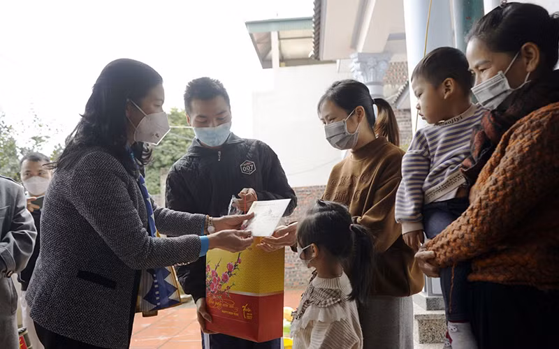 Lãnh đạo Liên đoàn Lao động thành phố Hà Nội (bên trái) trao quà tặng công nhân không về quê đón Tết.