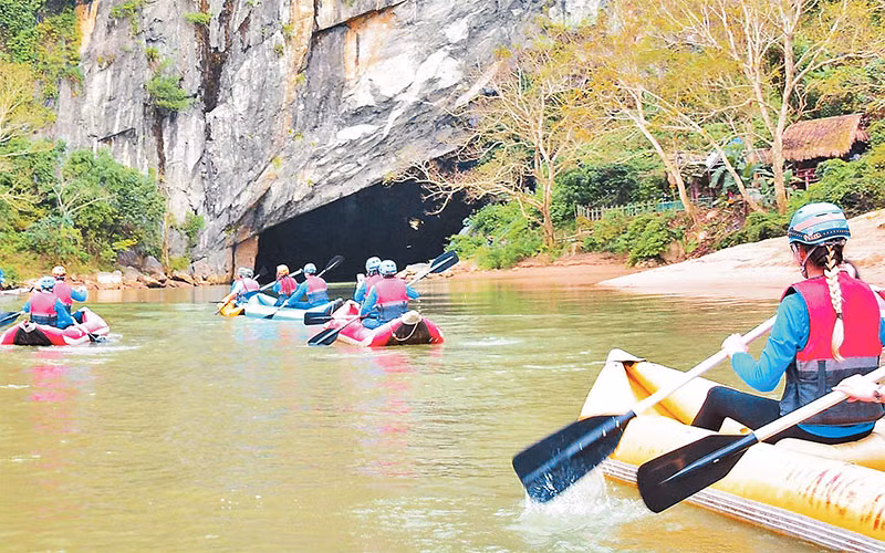 Khách du lịch khám phá động Phong Nha (Quảng Bình) bằng thuyền Kayak. 