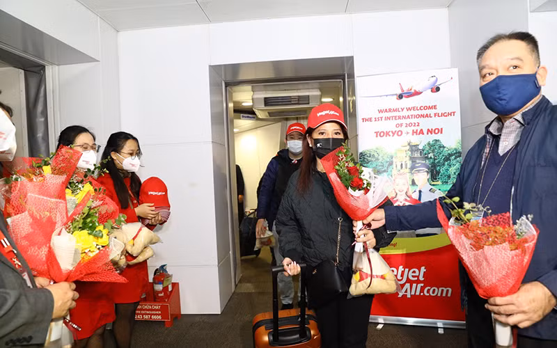 Lãnh đạo Cục Hàng không tặng hoa cho hành khách trên chuyến bay. (Ảnh: Hãng hàng không Vietjet cung cấp)