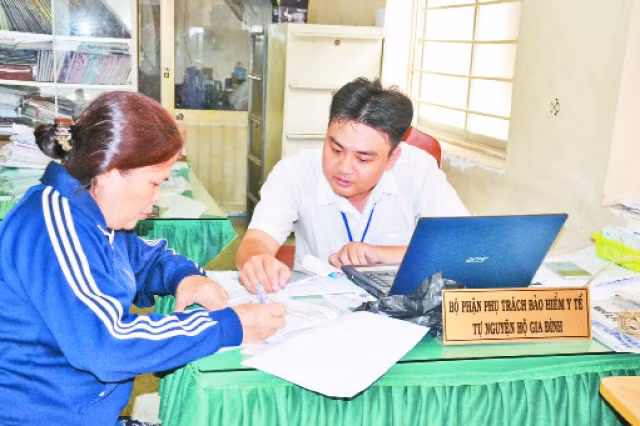 Học tập và làm theo phong cách Hồ Chí Minh, cán bộ phường 9, quận 11 tận tình hướng dẫn người dân thủ tục mua bảo hiểm y tế tự nguyện hộ gia đình.
