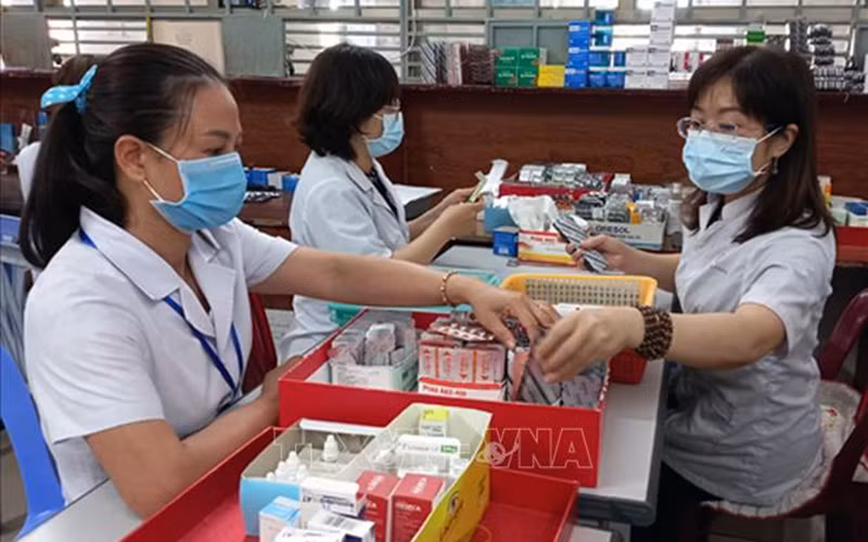 Nhân viên y tế chuẩn bị thuốc để cấp cho bệnh nhân điều trị ngoại trú có tham gia bảo hiểm y tế. (Ảnh minh họa: TTXVN)