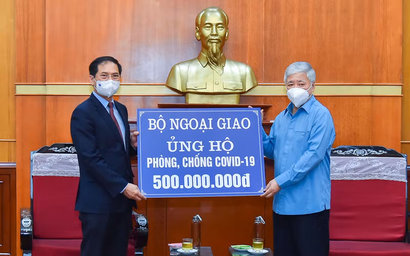 Bộ trưởng Ngoại giao Bùi Thanh Sơn trao tượng trưng số tiền 500 triệu đồng tới Bí thư Trung ương Đảng, Chủ tịch Ủy ban Trung ương Mặt trận Tổ quốc Việt Nam Đỗ Văn Chiến. (Ảnh: MOFA)