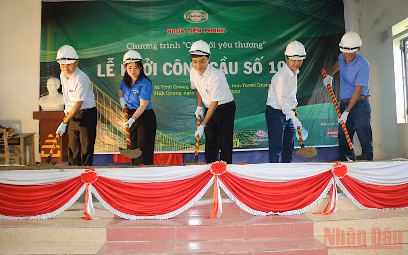 Các đại biểu và nhà tài trợ thực hiện động tác khởi công xây dựng cầu.
