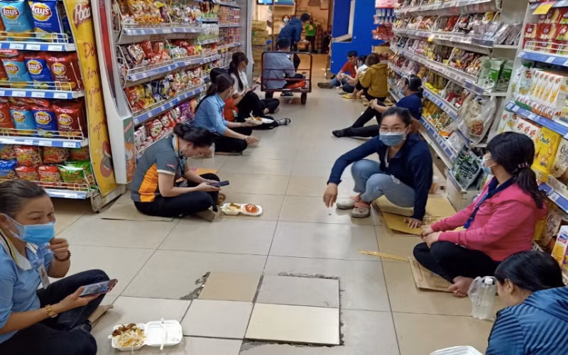 Hình ảnh các nhân viên đang cách ly tại một cửa hàng thực phẩm tại quận 1, TP Hồ Chí Minh trong thời gian chờ kết quả xét nghiệm.