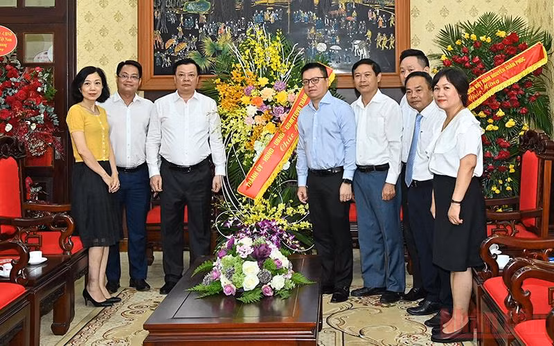 Bí thư Thành ủy Đinh Tiến Dũng tặng hoa chúc mừng Báo Nhân Dân nhân Ngày Báo chí cách mạng Việt Nam. (Ảnh: DUY LINH)