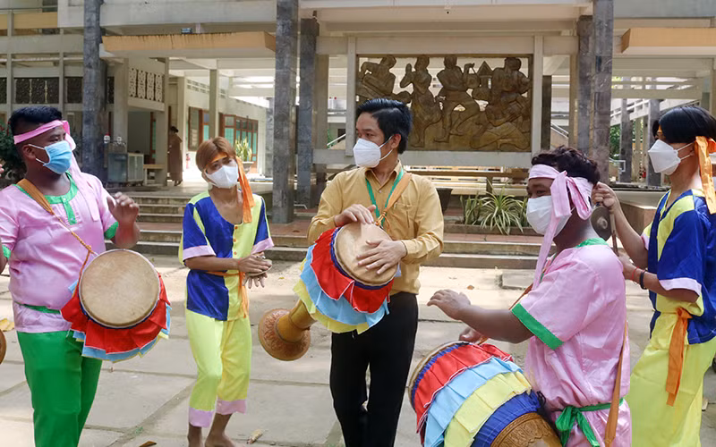 Du khách tham gia biểu diễn nhạc cụ dân gian tại “Làng Văn hóa du lịch Khmer Trà Vinh”. 