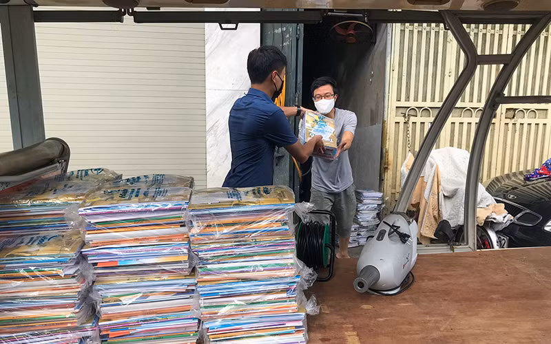 Lực lượng chức năng phường Chương Dương (quận Hoàn Kiếm, TP Hà Nội) chuyển sách giáo khoa đến tận nhà cho học sinh tại khu vực bị phong tỏa. Ảnh: MINH HÀ 