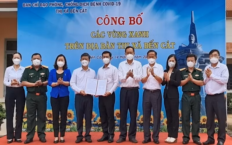 Chủ tịch UBND tỉnh Bình Dương Võ Văn Minh (thứ 4 từ trái sang) trao quyết định công bố “vùng xanh” cho lãnh đạo thị xã Bến Cát. 