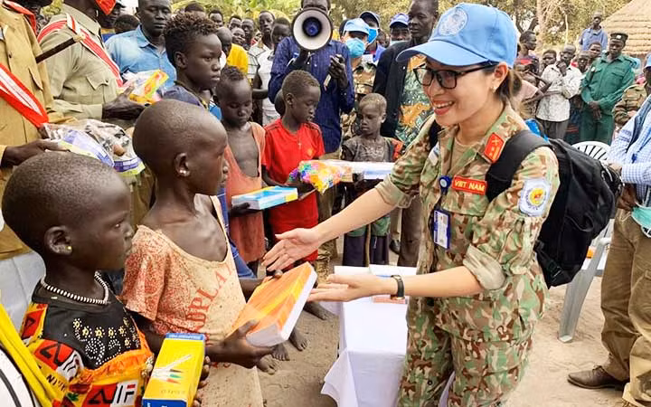Sĩ quan lực lượng gìn giữ hòa bình Việt Nam tặng quà cho trẻ em Nam Sudan. (Ảnh: CỤC GÌN GIỮ HÒA BÌNH VIỆT NAM)