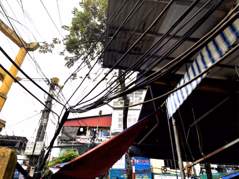 Dây điện sà xuống đường gây nguy hiểm cho người dân -0