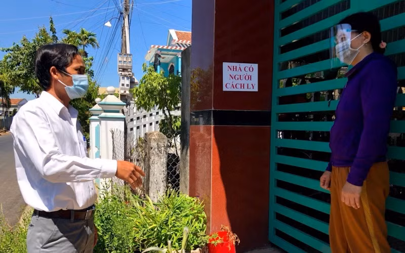 Thành viên Tổ Covid cộng đồng ở huyện Mộ Đức (Quảng Ngãi) nhắc nhở gia đình có người cách ly tại nhà thực hiện nghiêm quy định phòng, chống dịch. 