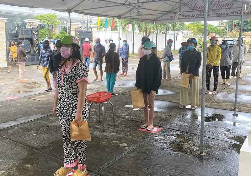 Người dân xếp hàng vào nhận gạo.