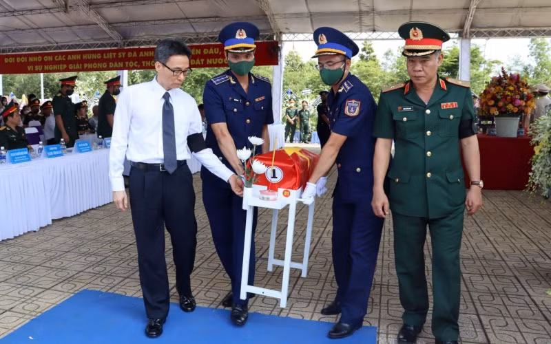 Phó Thủ tướng Vũ Đức Đam thực hiện nghi thức di quách hài cốt liệt sĩ.