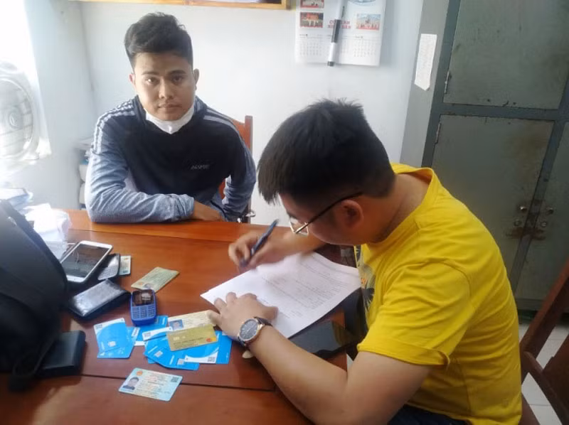 Đối tượng Nguyễn Bá Cường (áo xám) tại Cơ quan công an. (Ảnh: Công an cung cấp).