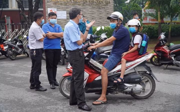 Phụ huynh đưa học sinh đến trường vào sáng 19-8.