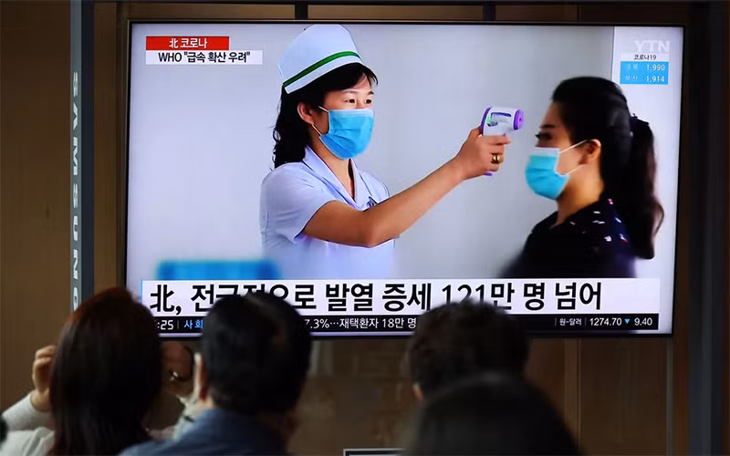 Người dân theo dõi bản tin về đợt bùng phát Covid-19 ở Triều Tiên, tại một nhà ga ở Seoul, Hàn Quốc, ngày 17/5. (Ảnh: Reuters)