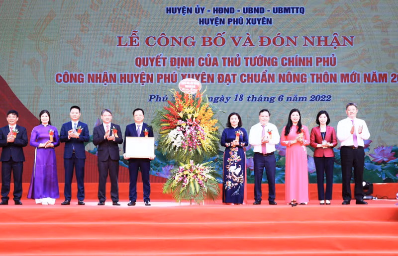 Lãnh đạo huyện Phú Xuyên đón nhận Quyết định của Thủ tướng Chính phủ công nhận huyện đạt chuẩn nông thôn mới năm 2020. (Ảnh: Ngọc Anh)
