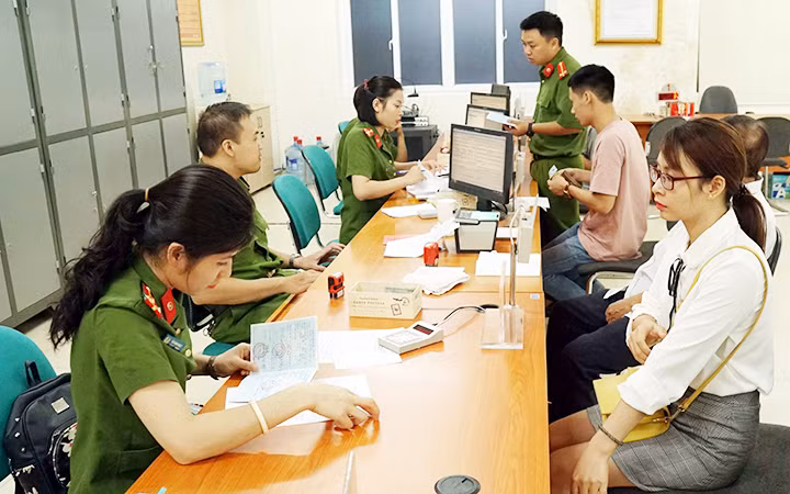 Các cán bộ chiến sĩ công an hỗ trợ người dân làm thủ tục đổi thẻ căn cước công dân tại Phòng Cảnh sát quản lý hành chính về trật tự xã hội (Hà Nội). Ảnh: PHƯƠNG MINH