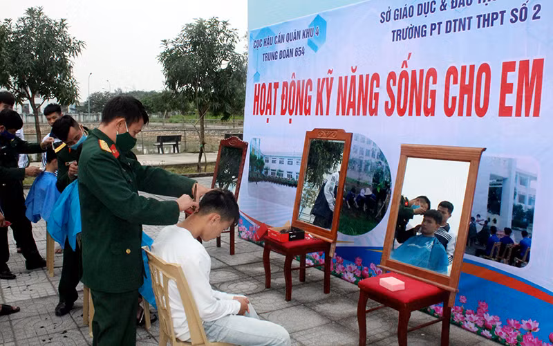 Cán bộ, chiến sĩ Trung đoàn 654 cắt tóc cho học sinh Trường dân tộc nội trú THPT số 2 tỉnh Nghệ An.