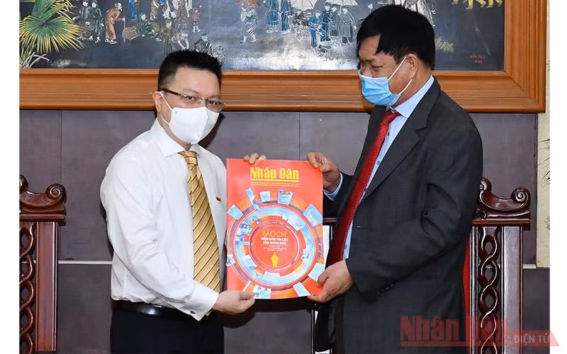 Đồng chí Lê Quốc Minh tặng đồng chí Huỳnh Tấn Việt (bên phải) số báo đặc biệt nhân ngày 21-6. (ẢNH: THỦY NGUYÊN)
